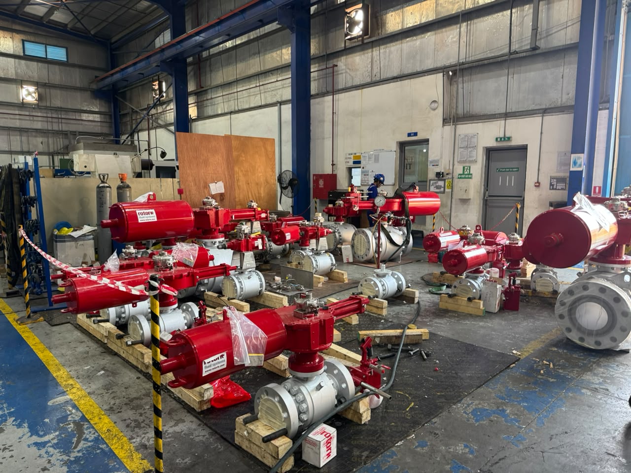 Completed valve and actuator packages arranged across a workshop floor